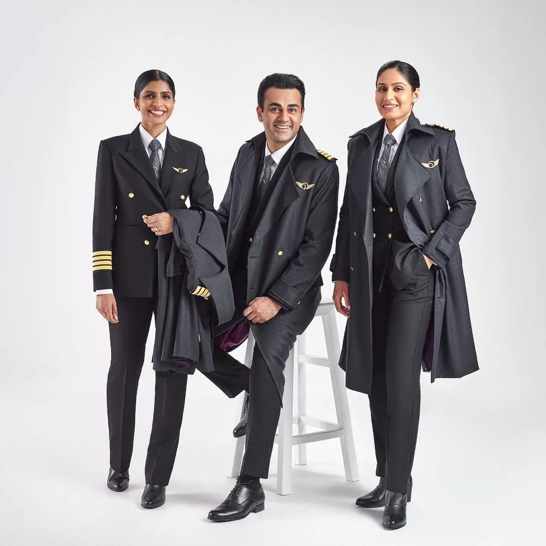 Three airline pilots in uniform smiling together